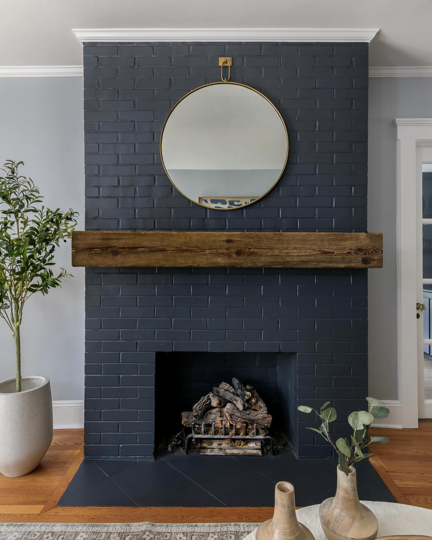 Balance Dark Brick with a Round Mirror and Warm Wood