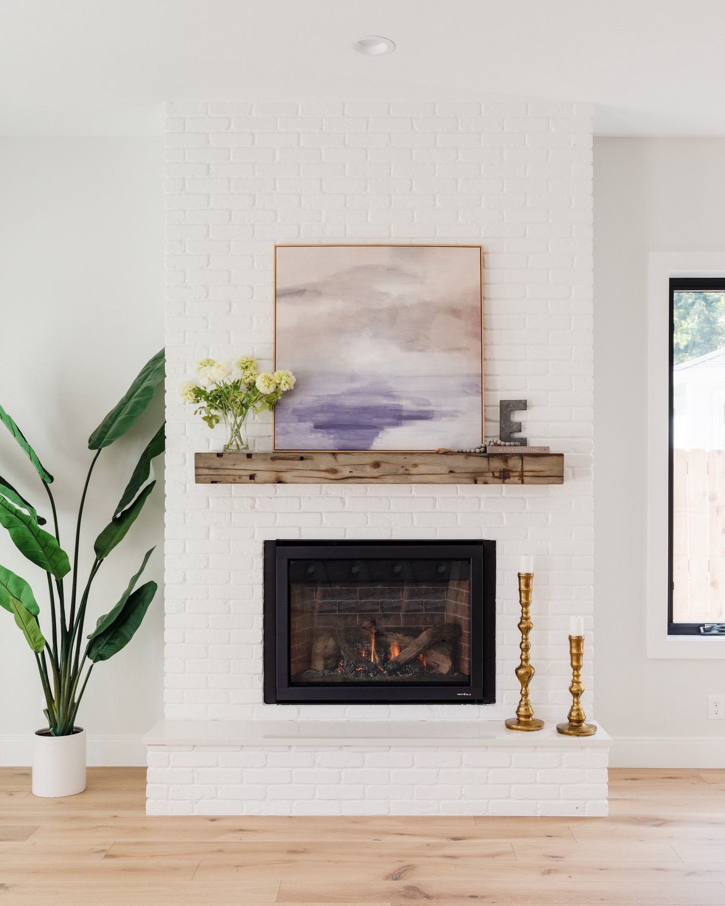 Let One Large Artwork Lead an All-White Fireplace