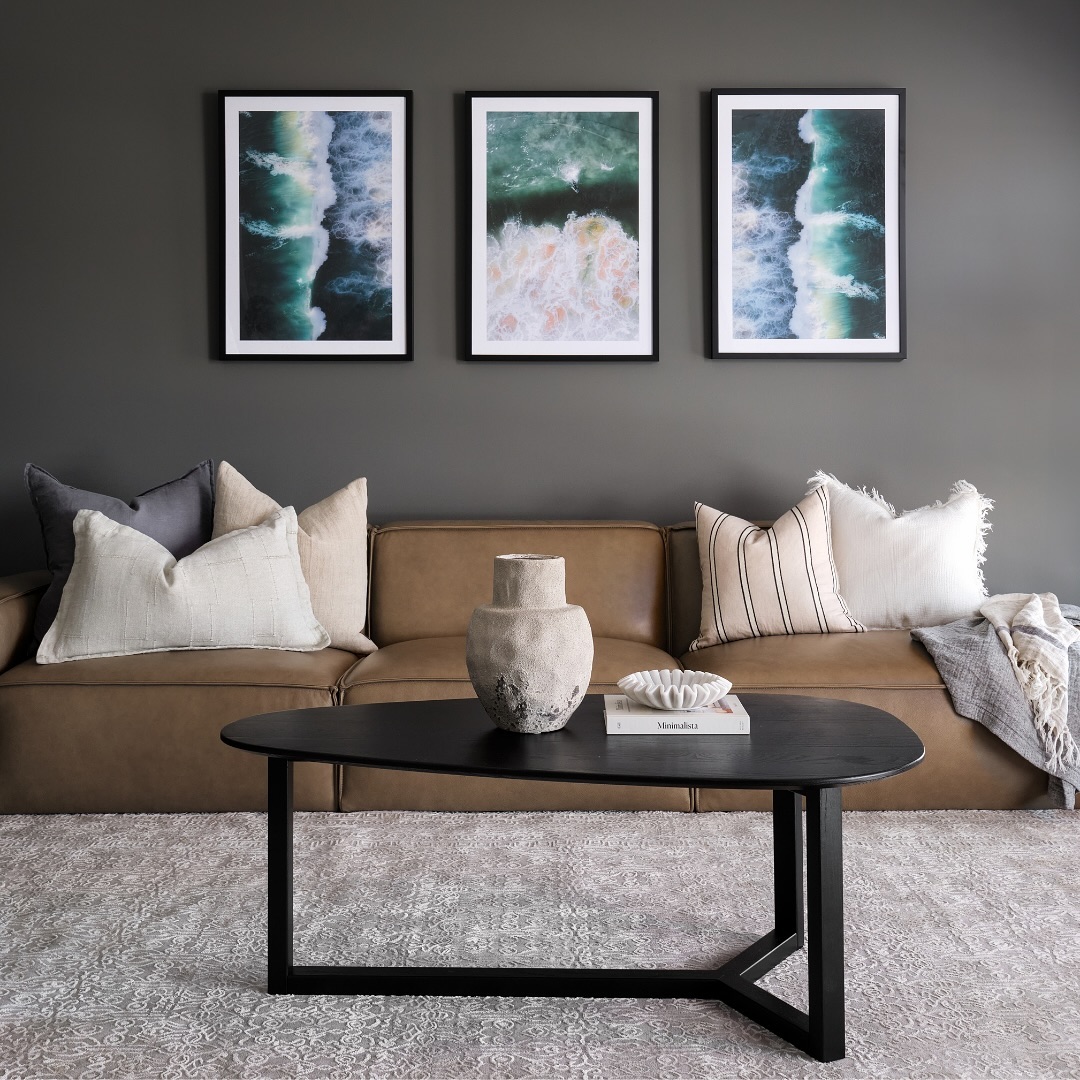17. Set Ocean Prints Above a Muted Cognac Sofa