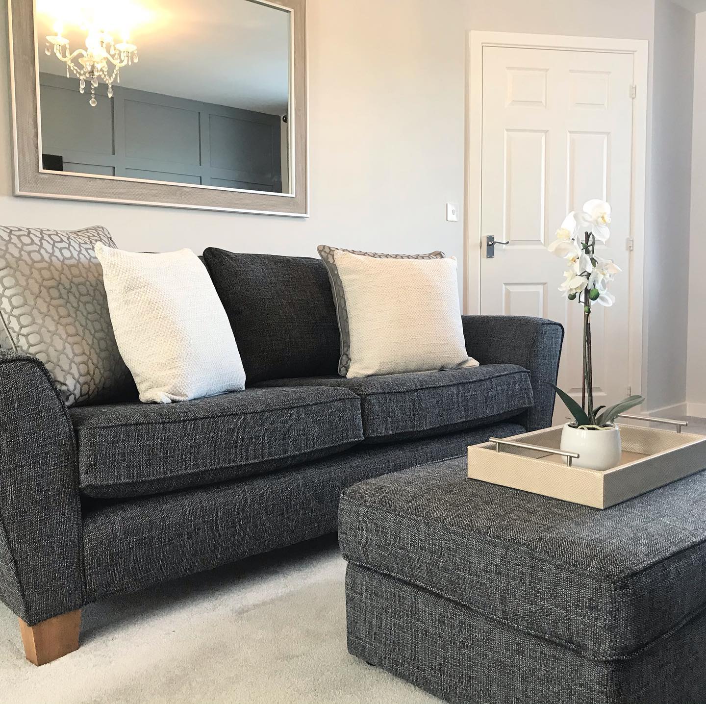 Hang a Broad Mirror Above a Compact Charcoal Sofa