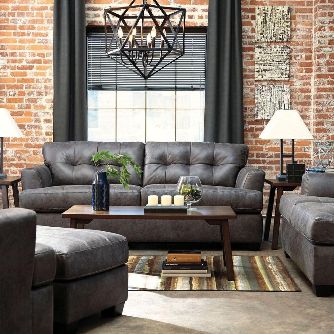 Set a Tufted Charcoal Sofa Against Warm Brick