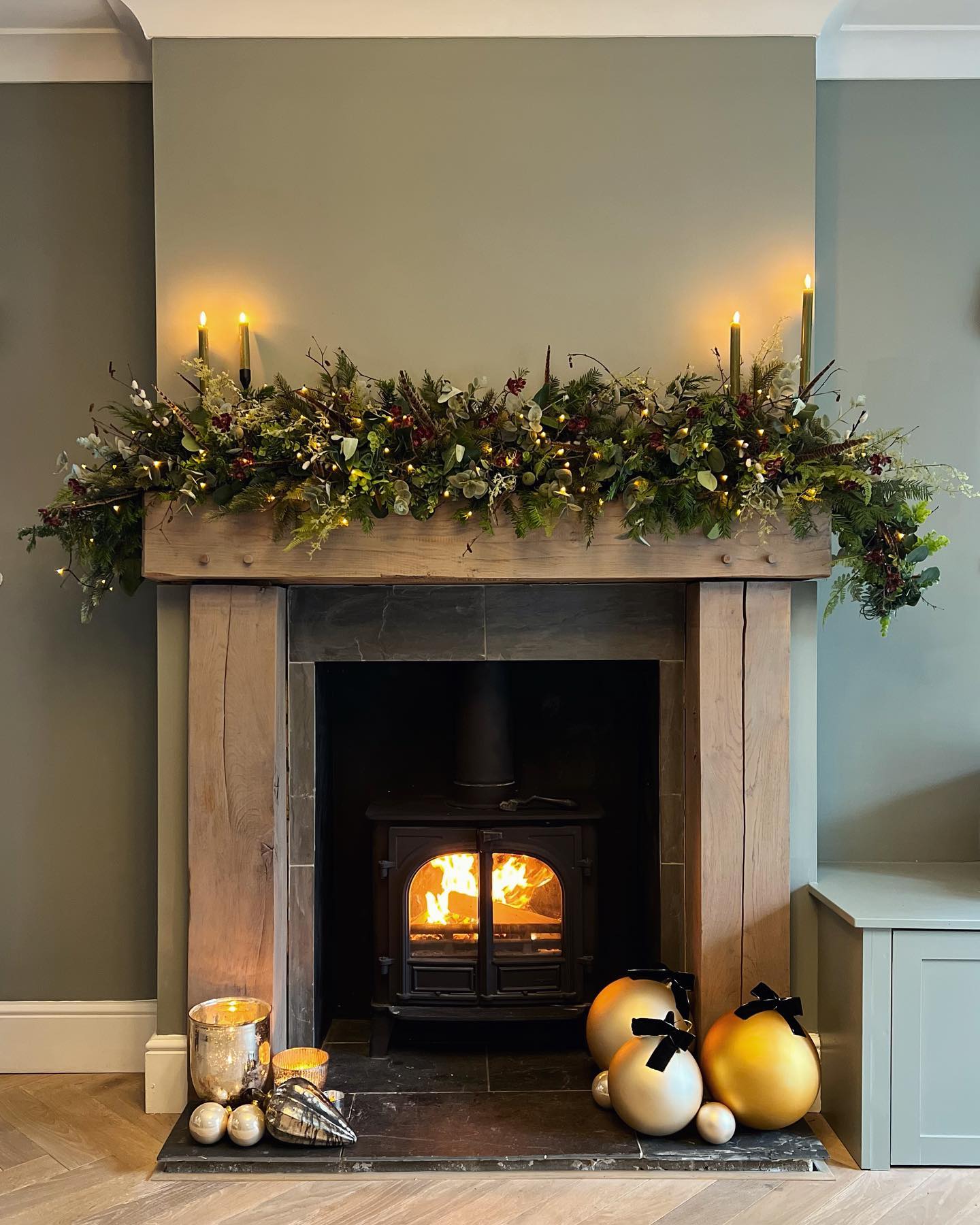 14. Warm a Sage Fireplace Wall with a Wood Surround