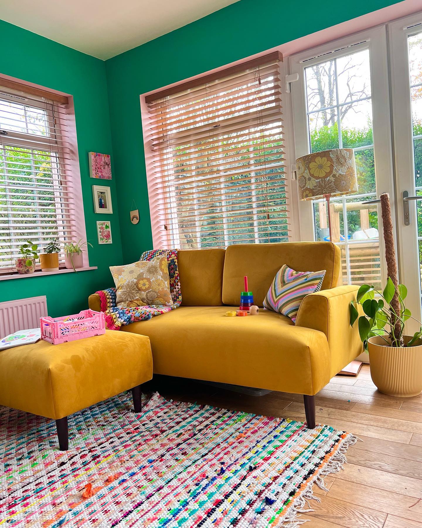 9. Pair Mustard Seating With Emerald Walls and Pink Trim