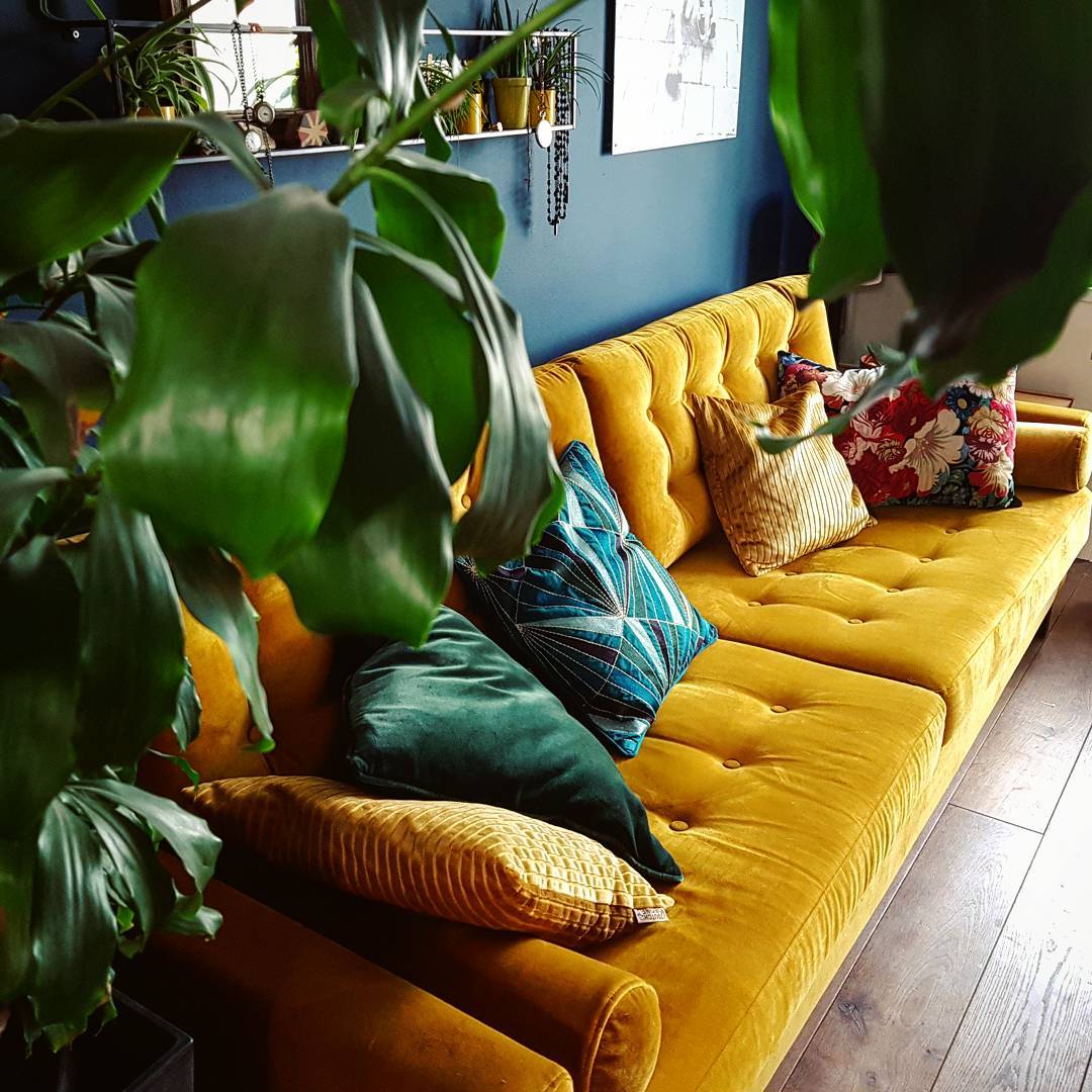13. Frame a Tufted Yellow Sofa With Greenery
