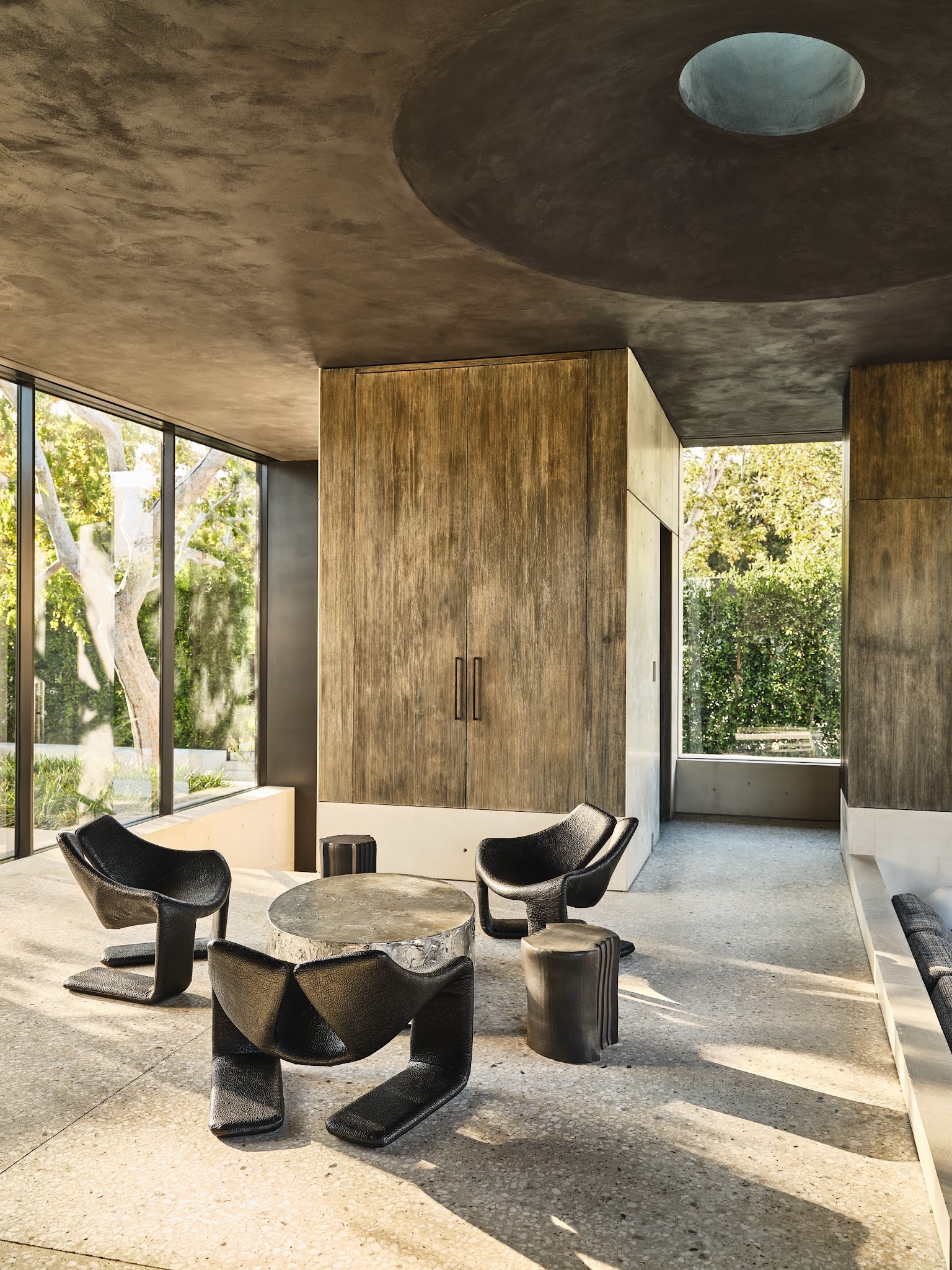 2. Set Sculptural Black Chairs Against Warm Brown Panels