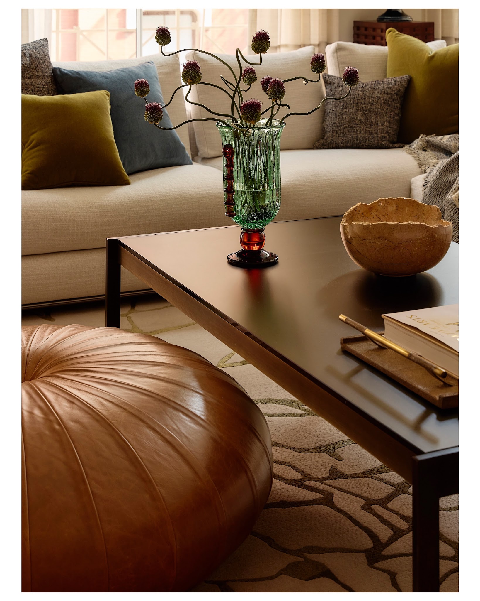 20. Soften a Black Table Frame With a Rounded Brown Pouf