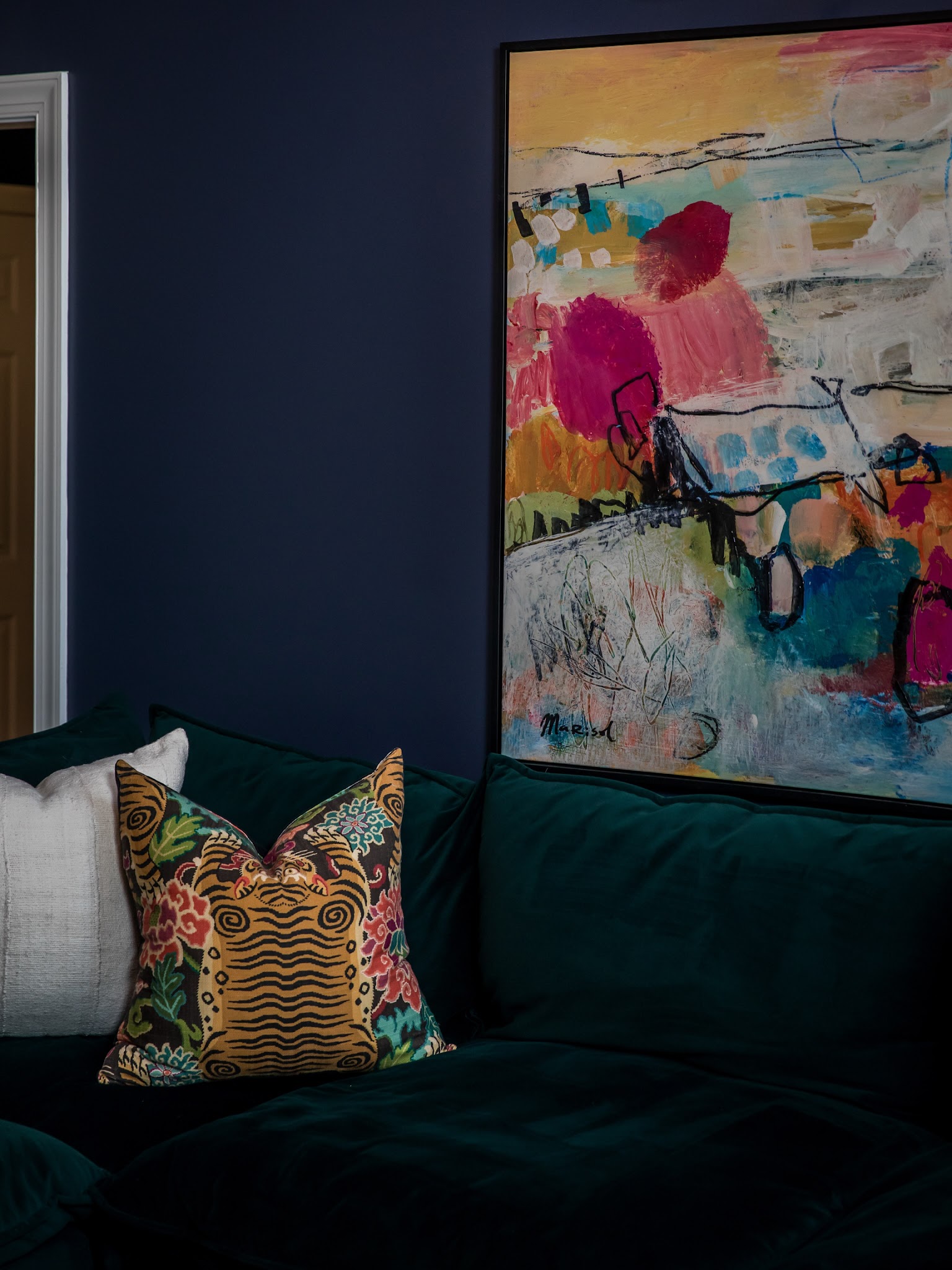 2. Deep Blue Walls Around an Emerald Sofa
