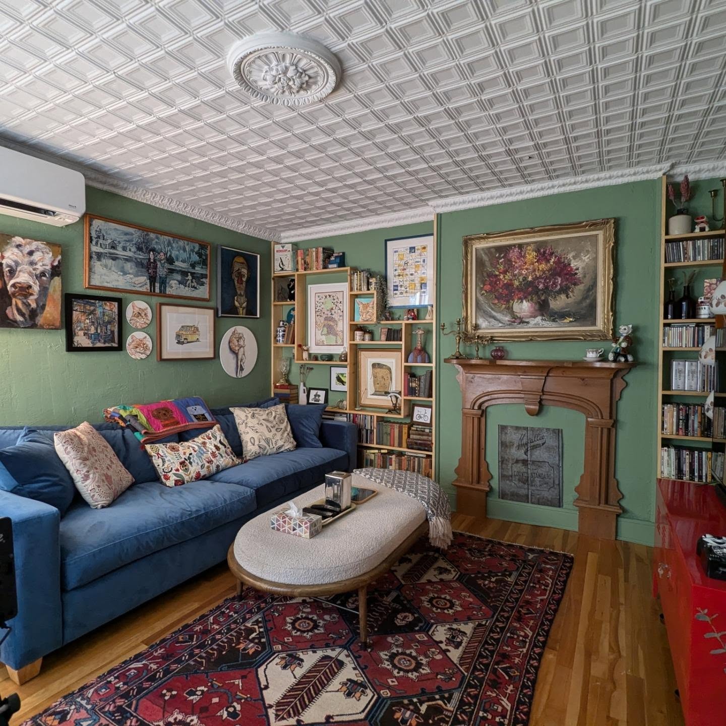 8. A Blue Sofa Against a Green Gallery Wall
