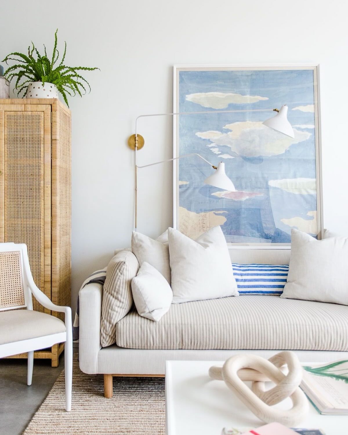13. Mix Sky Blue Art With a Natural Cane Cabinet