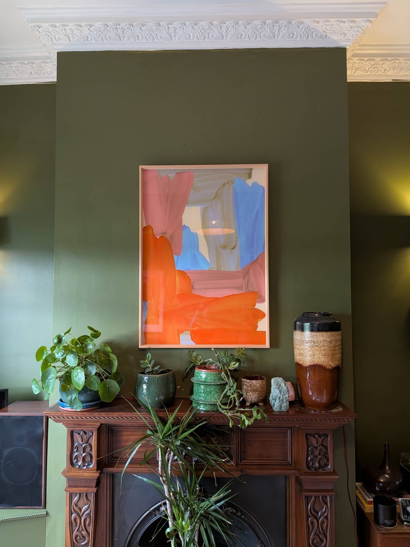 4. Wake Up an Olive Fireplace With Orange Art