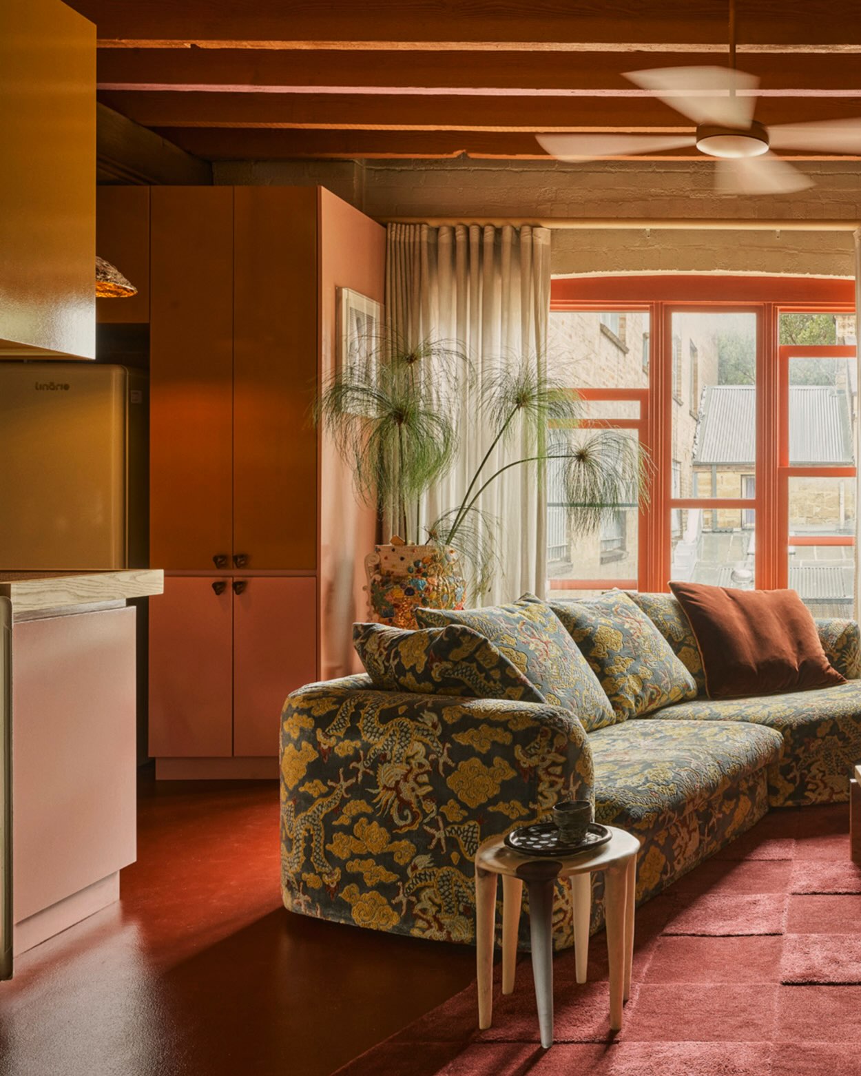 13. Repeat Rust Around a Green Patterned Sofa