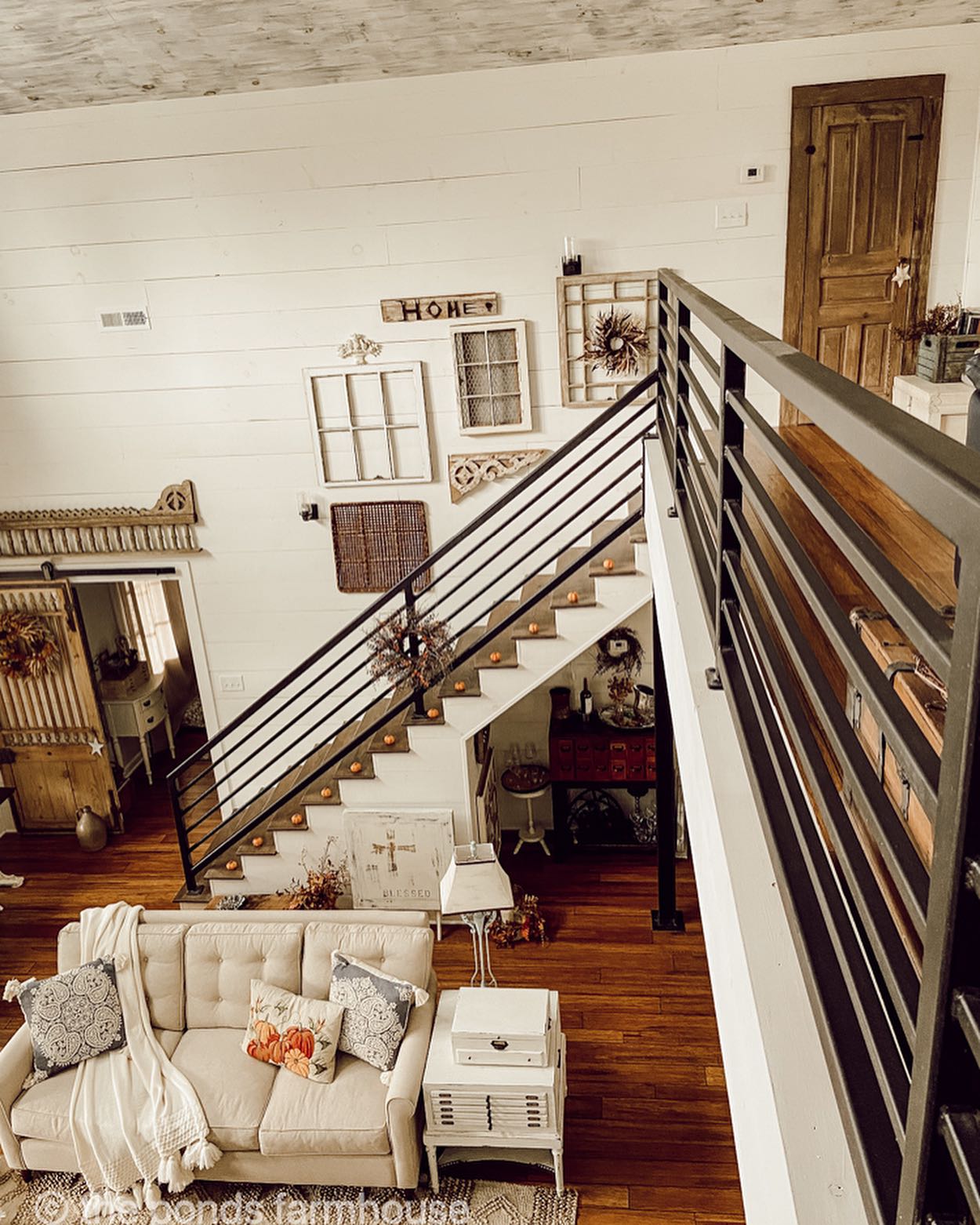 4. Let Dark Stair Rails Frame a Soft Sitting Area