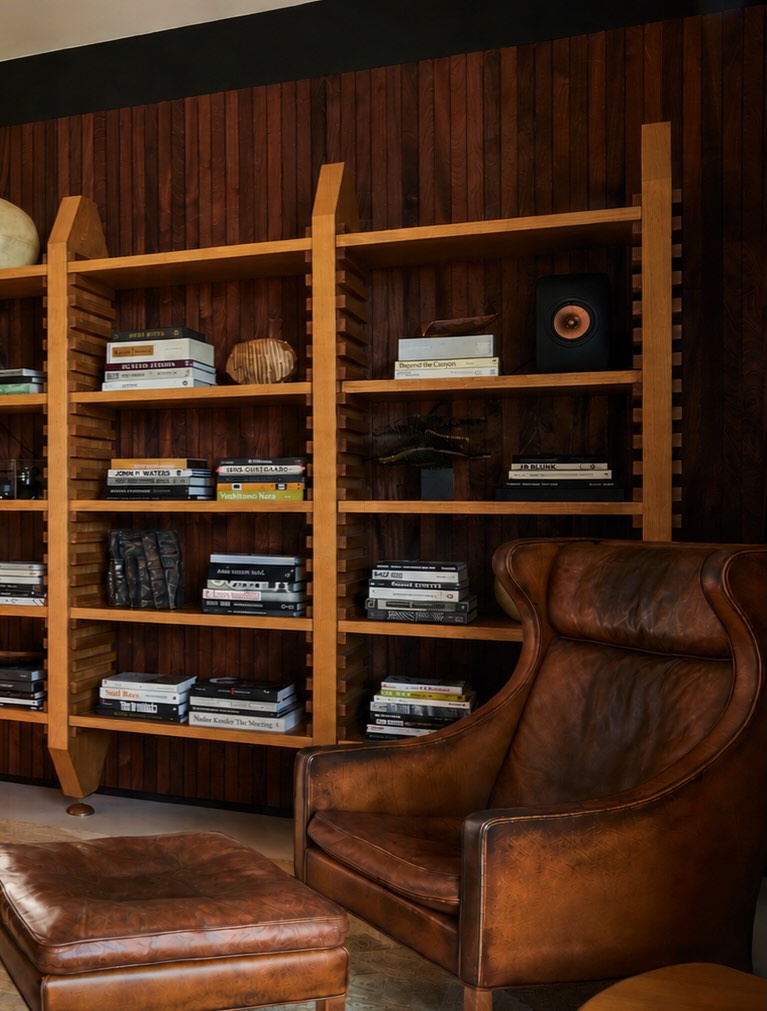 11. Layer Light Wood Shelves Against Dark Paneling