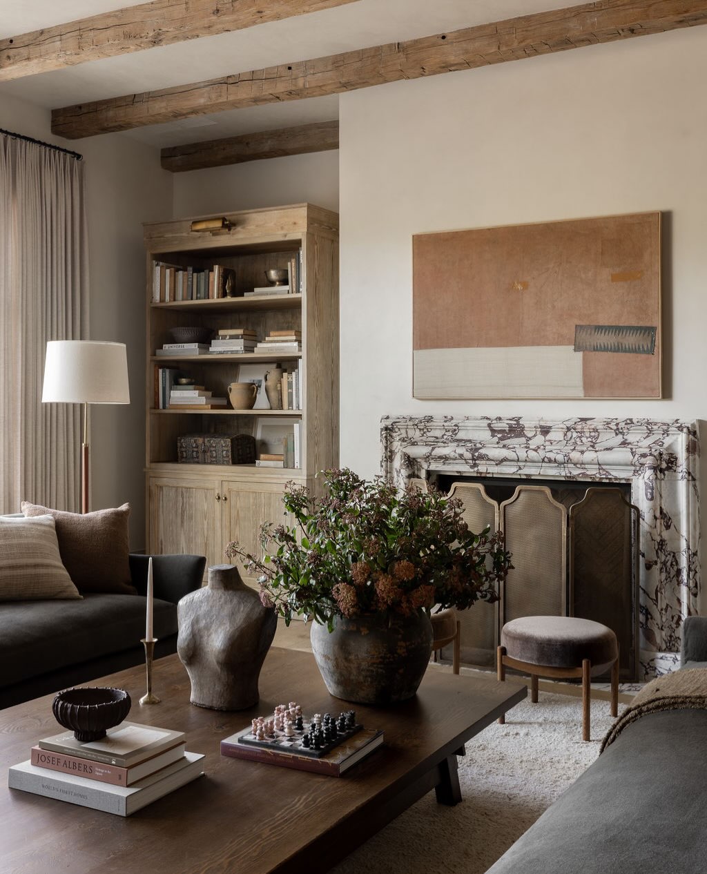 6. Mix Rough Beams With a Refined Stone Fireplace