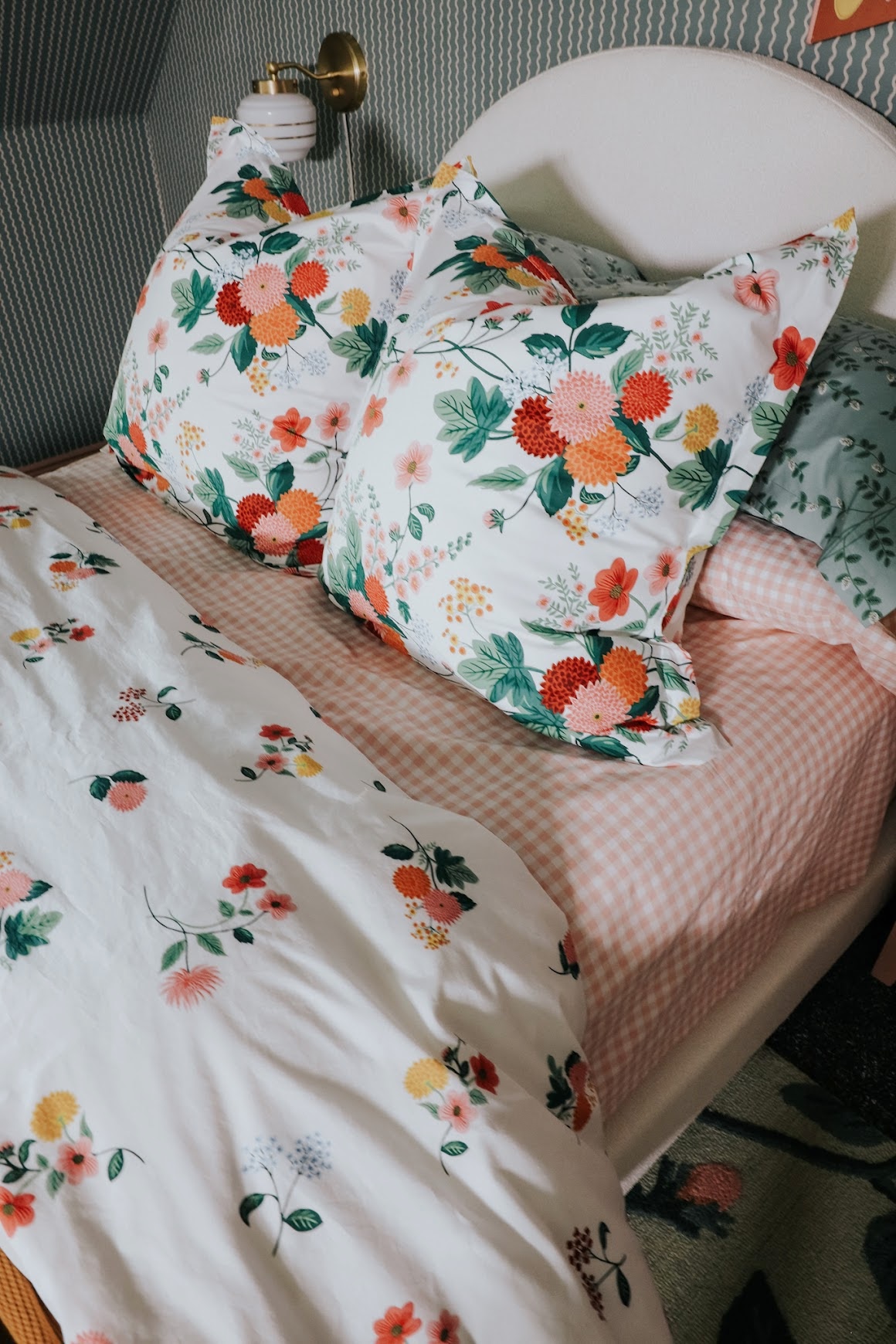 9. Let Blush Gingham Show Beneath Green Botanical Pillows