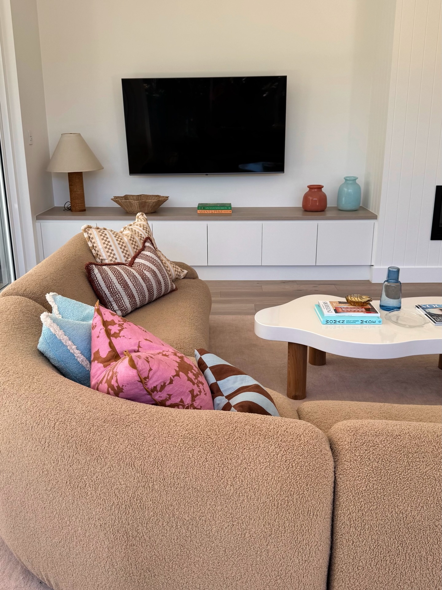 3. A Curved Taupe Sofa With Playful Pillows
