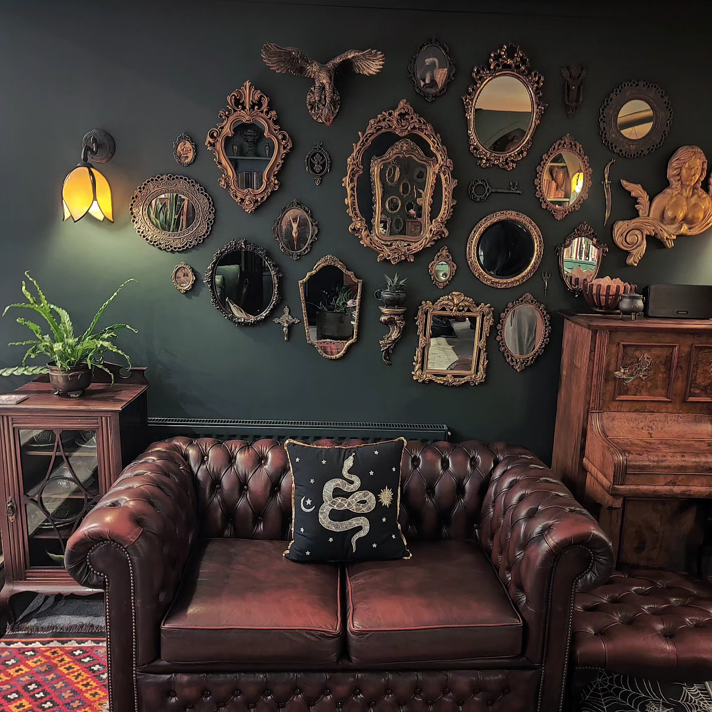 15. Collect Ornate Mirrors Above a Leather Loveseat